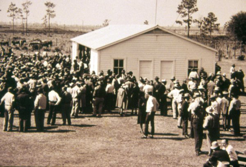 Crowd gathered around field building at early RCREC field day