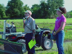 A professor presents while staniding next to a tractor at Pasture Field Day 2007